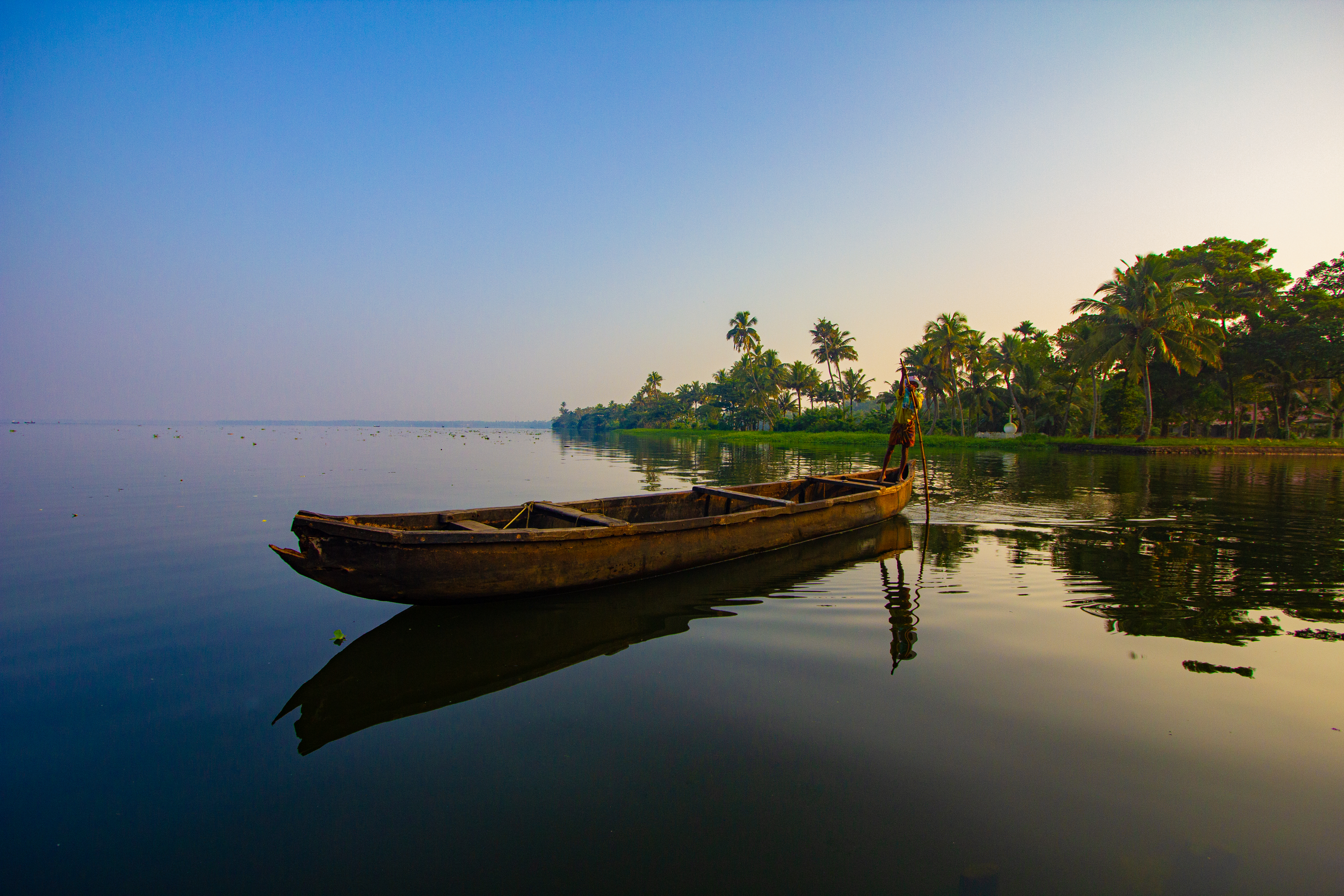 Kumarakom backwater Kerala — serene wetland waterways at dawn with traditional boats